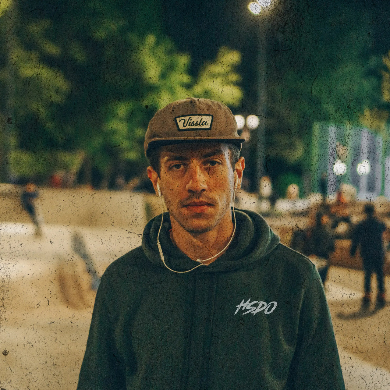 Teen wearing a green hoodie at the skate park